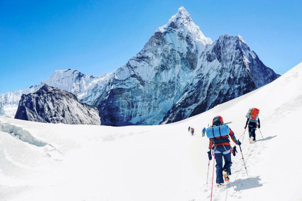 Alpinisti attraversano un paesaggio innevato con vista sulle montagne