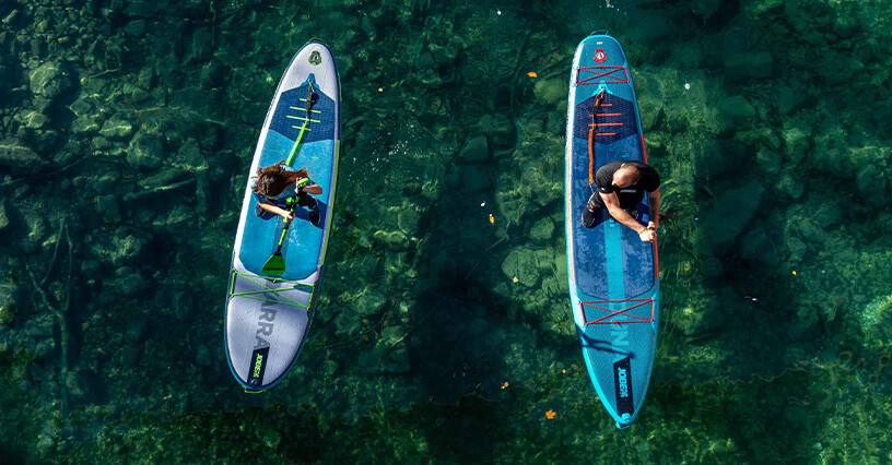 Due persone praticano paddleboarding su acque cristalline