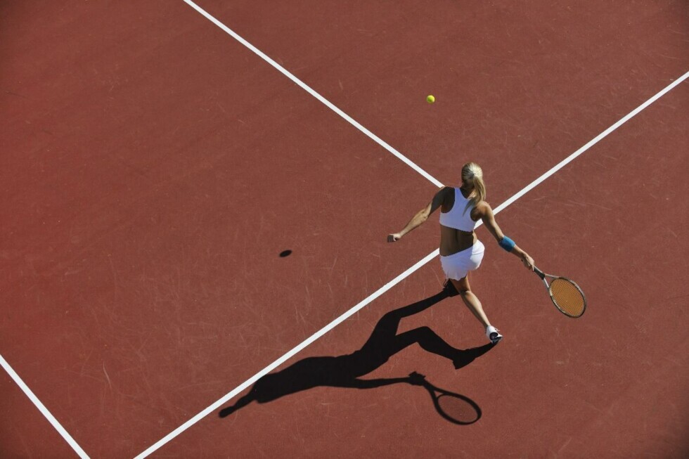 Giocatrice di tennis in azione su campo rosso