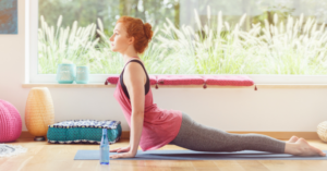 Persona che pratica yoga su un tappetino davanti a una finestra