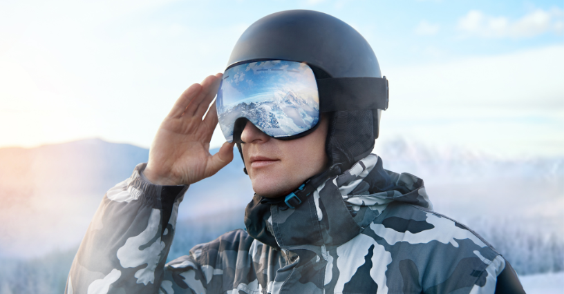 Una persona indossa un casco e occhiali da sci in montagna