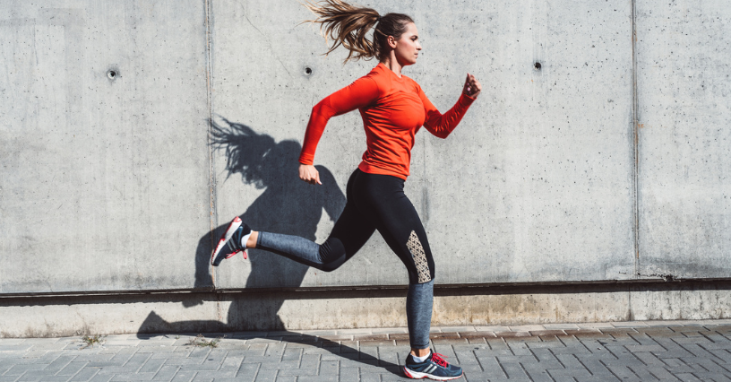 Donna corre all'aperto con abbigliamento sportivo