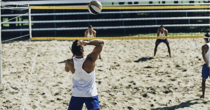 Un giocatore esegue un servizio di pallavolo su sabbia