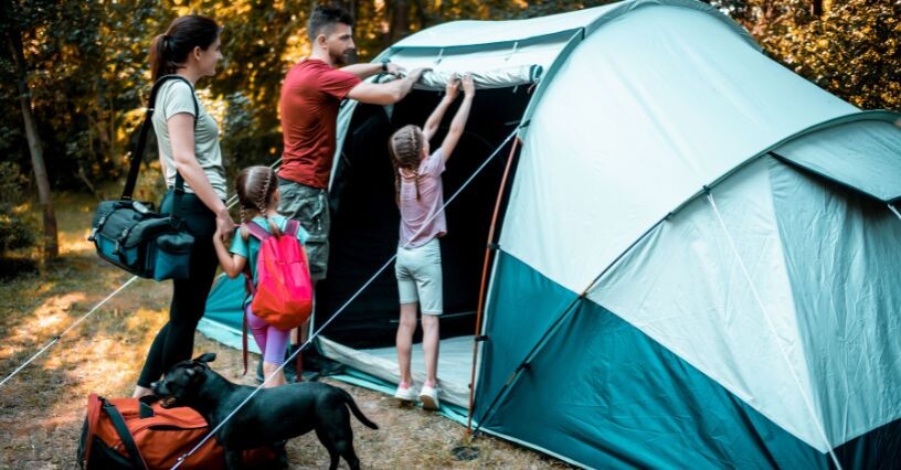 Famiglia monta una tenda da campeggio spaziosa per una vacanza all'aperto